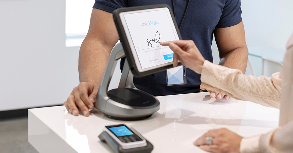 Person signing signature on a convertible mPOS, NE360, InVue