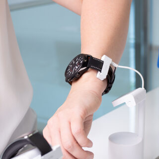 Customer trying on smart watch in store, secured by wearables solution. Alarmed.