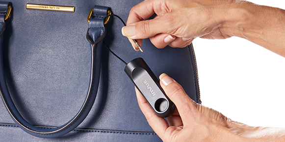 Attaching a IR cable security tag on expensive handbag, apparel, fashion store