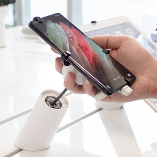 Mobile phone being lifted by customer, secured by OnePOD recoiler.