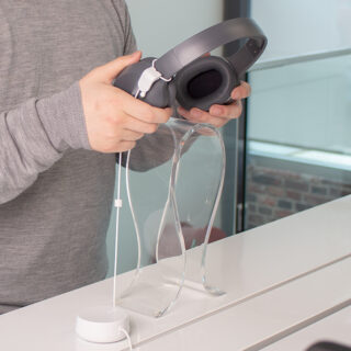 Zips recoiler for headphones, man testing headphones in retail environment