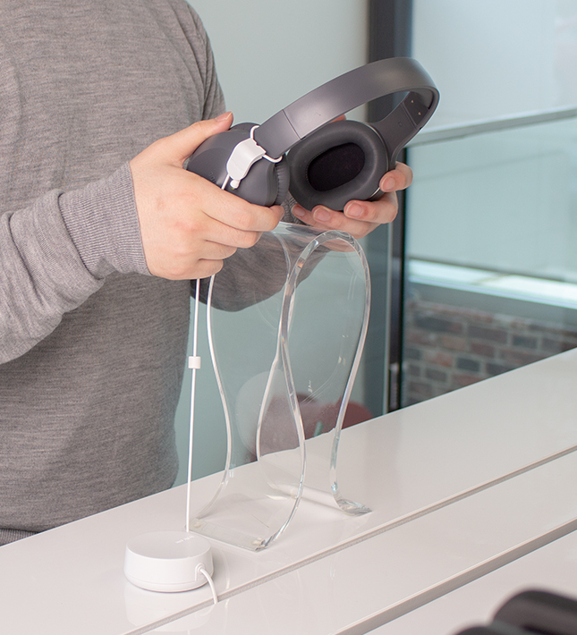 Zips recoiler for headphones, man testing headphones in retail environment