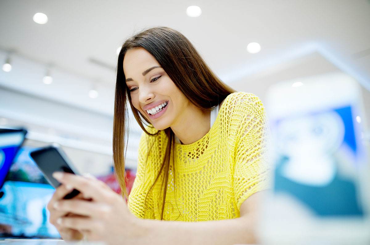 women looking happy as she looks at her phone