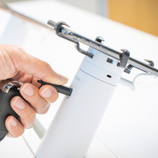 One60 phone stand, hand holding magnetic key and OneKEY