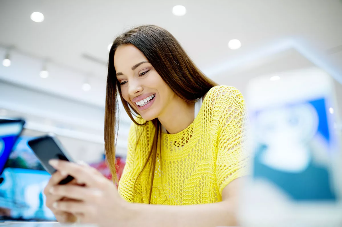 women looking happy as she looks at her phone